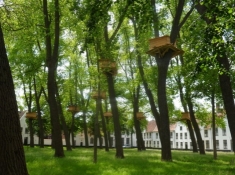 En anderledes klostergård med træhuse i træerne/A peculiar inner yard with houses in the trees