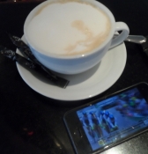 Simon drikker kaffe og ser Tourʹen på sin mobil/Simon has coffee and the Tour on his cell phone