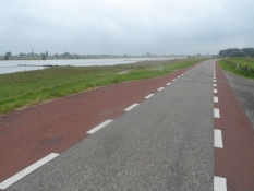 Vej på diget langs Lek med smalle cykelstriber/Road on the Lek dike with narrow bike lanes