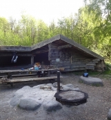 Schlafort und Feuerstelle des Zeltplatzes im Wald Pinseskoven