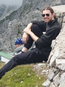 Thomas ruht seine Beine aus auf dem Berggipfel
